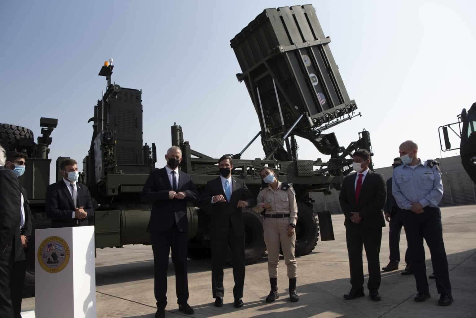 Iron Dome launcher with its Tamir interceptor tubes raised on an Israeli air base, with officials standing in front