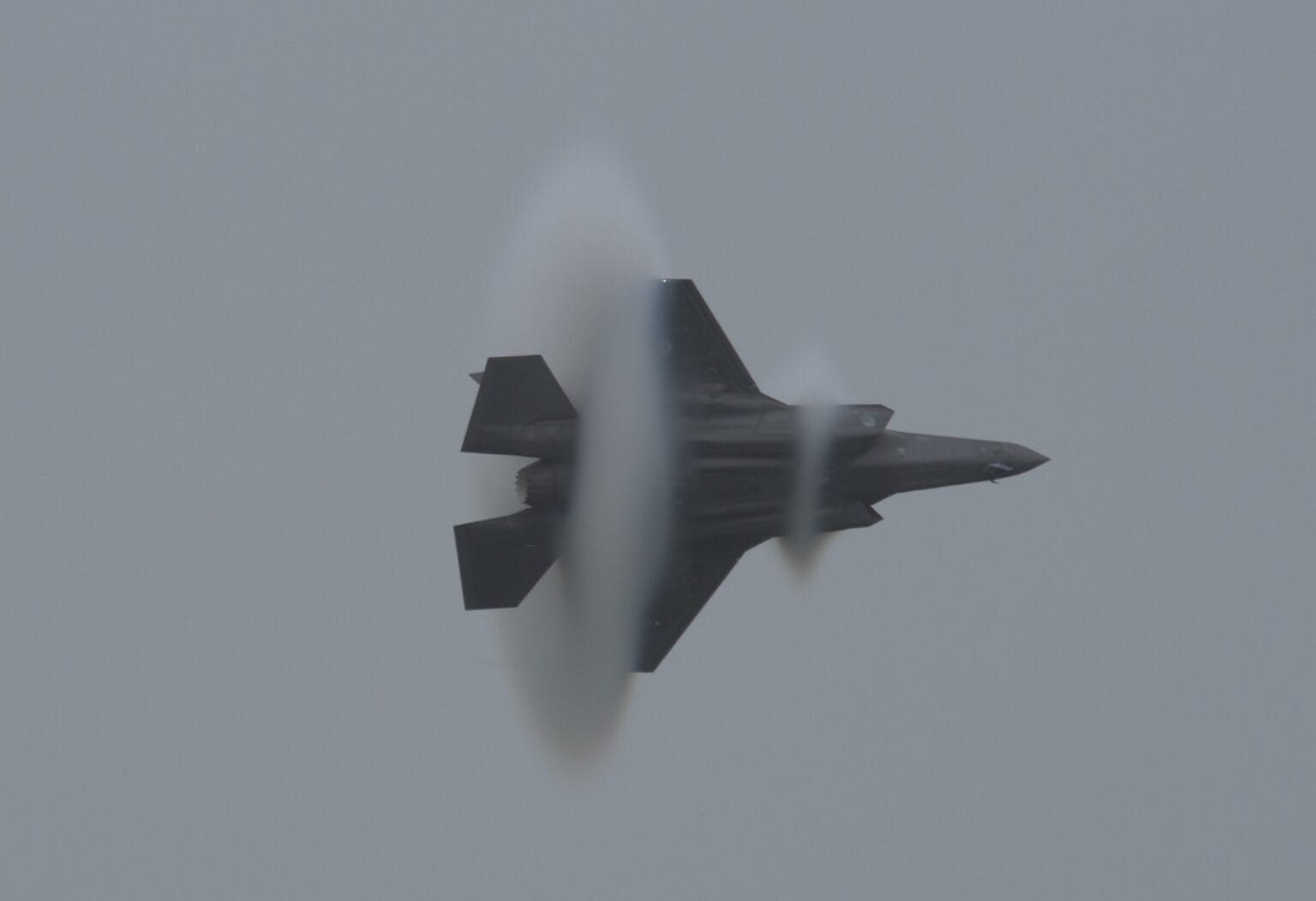 Lockheed Martin F-35 Lightning II wrapped in a double vapor cone as it banks at an airshow