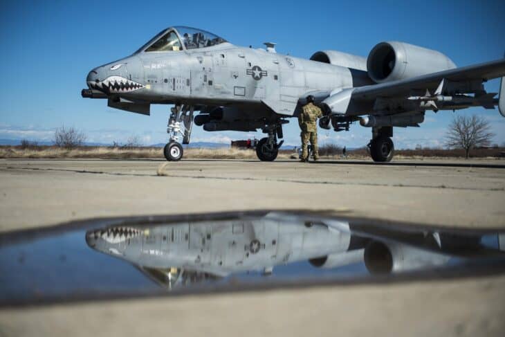 US Air Force A-10C Thunderbolt II with shark-mouth nose art being refueled on a wet ramp at Plovdiv, Bulgaria, reflected in a puddle