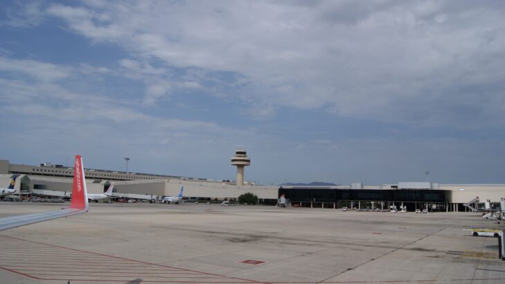 Palma de Mallorca Airport apron with the control tower and parked airliners under a cloudy sky