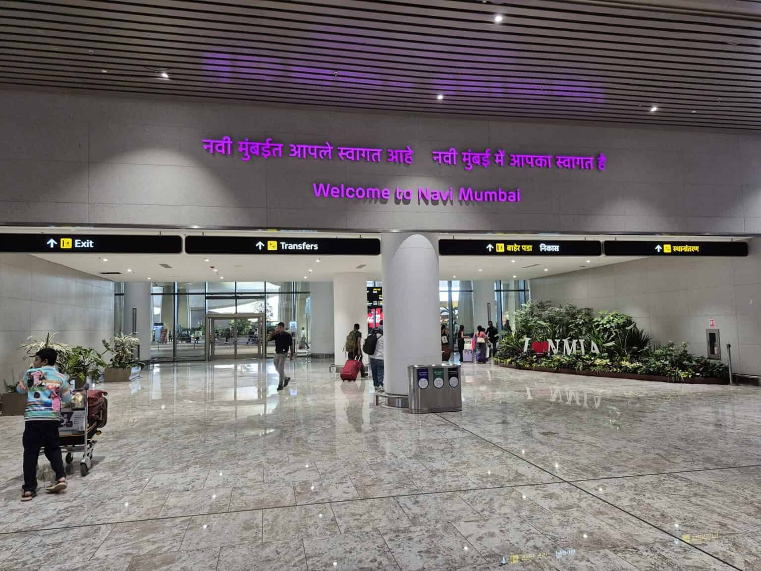 Arrivals hall at Navi Mumbai International Airport with a Welcome to Navi Mumbai sign