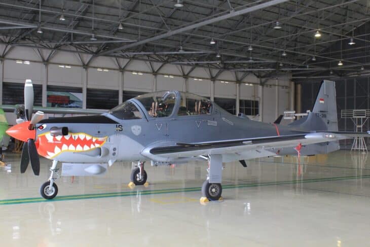 Indonesian Air Force EMB-314 Super Tucano with shark-mouth nose art in a hangar