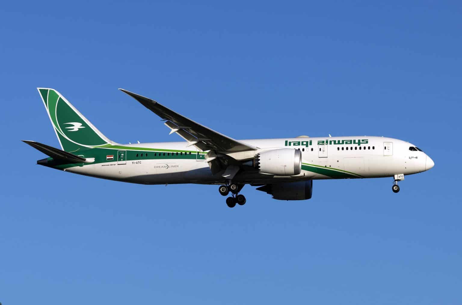 Iraqi Airways Boeing 787 Dreamliner YI-ATC in flight with its landing gear down against a clear blue sky