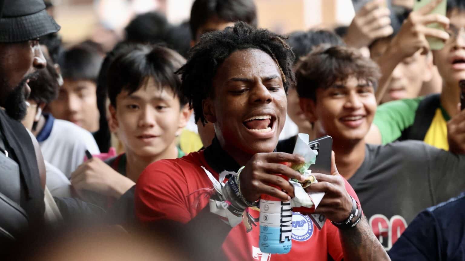 IShowSpeed in a red jersey shouting to a packed crowd of fans with phones raised