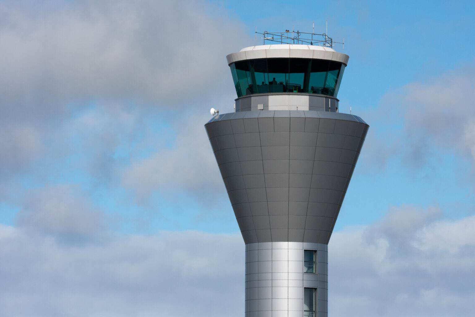 The control tower at Jersey Airport against a blue sky with clouds