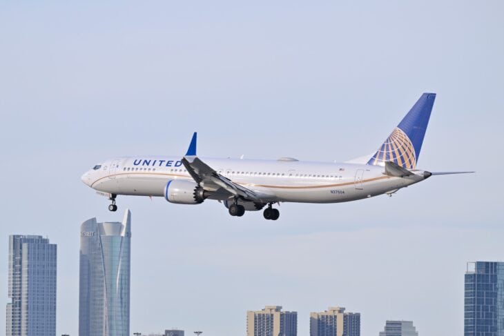 United Airlines Boeing 737-9 MAX N37504 landing with a city skyline behind
