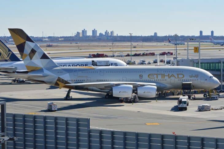 Etihad Airways Airbus A380 A6-APA on stand at JFK Terminal 4 with the Manhattan skyline in the distance