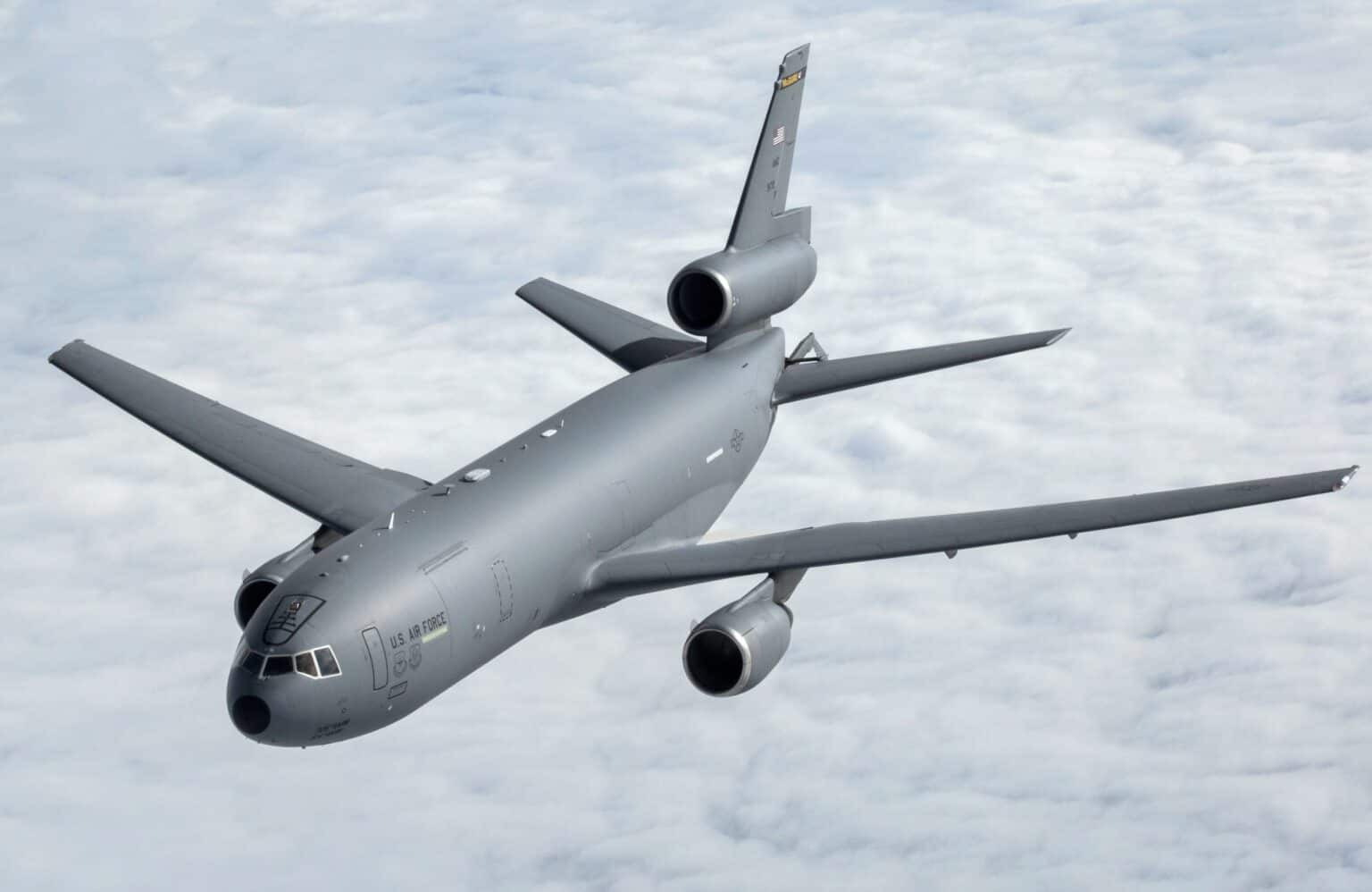 Gray USAF KC-10A Extender tanker banking above a layer of cloud