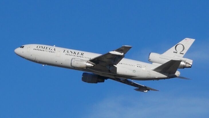 Omega Tanker KDC-10 with the Omega logo on its tail climbing out against a blue sky