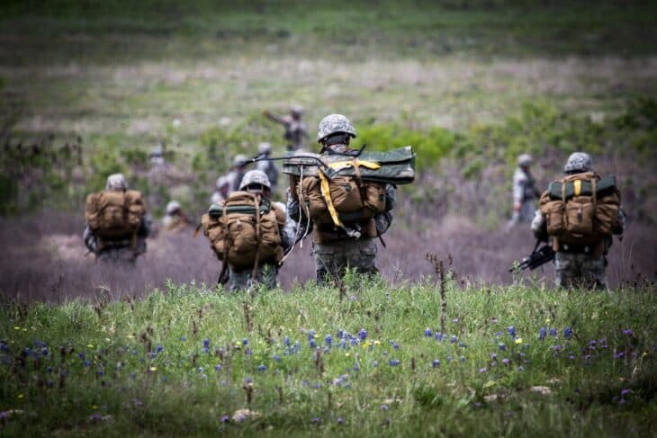 Paratroopers walking through a spring meadow near Fort Hood