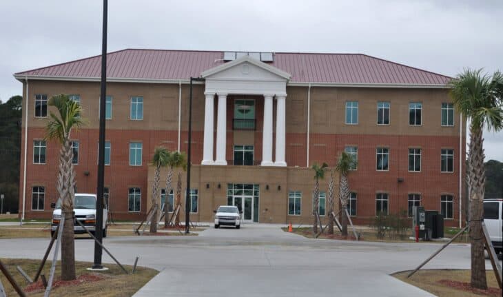 Brick Warrior in Transition barracks building with palm trees at Fort Stewart