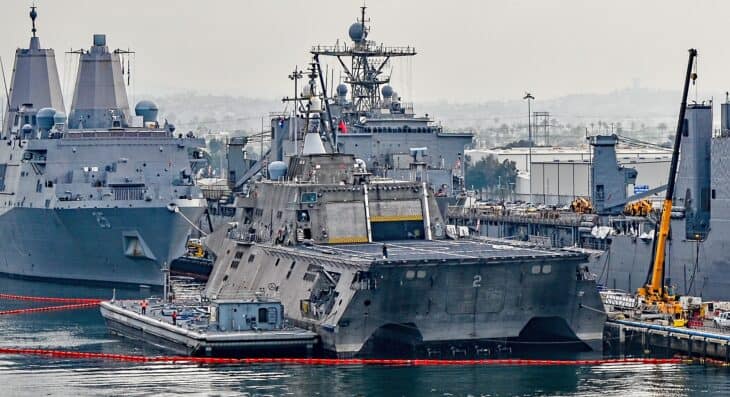 Littoral combat ship USS Independence moored at Naval Base San Diego with amphibious ships behind