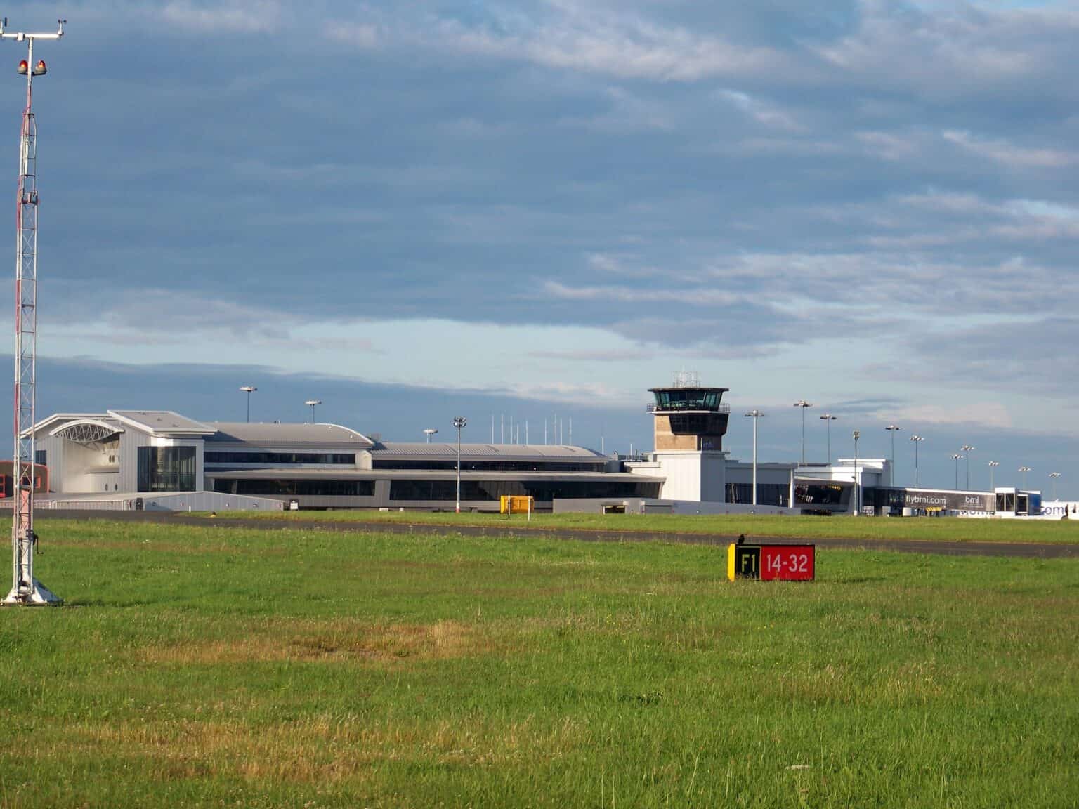 Leeds Bradford Airport terminal building and control tower seen across grass from the airfield