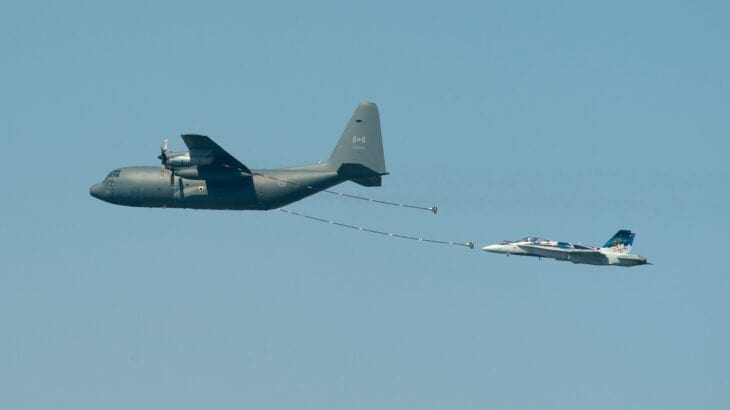 CC-130H Hercules 130339 trailing refueling hoses over Toronto with a CF-18 behind