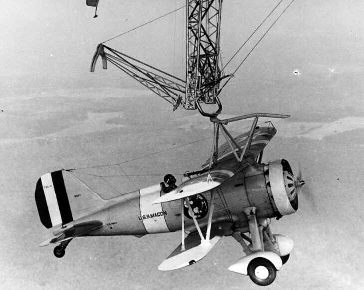 Curtiss F9C Sparrowhawk biplane hooked onto the trapeze of a US Navy airship