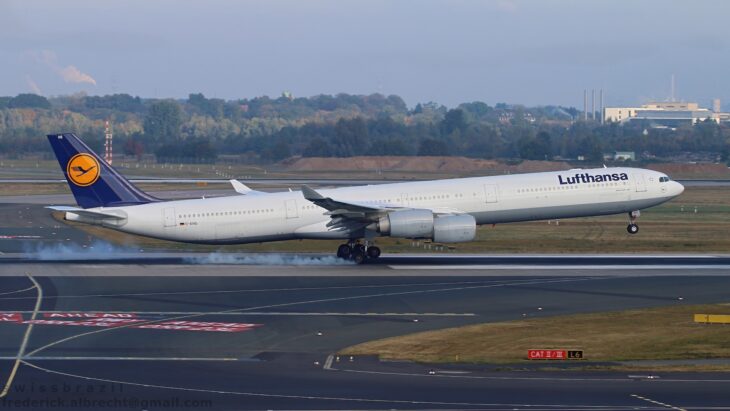 Lufthansa Airbus A340-600 D-AIHS touching down at Düsseldorf Airport, tire smoke rising from its main landing gear