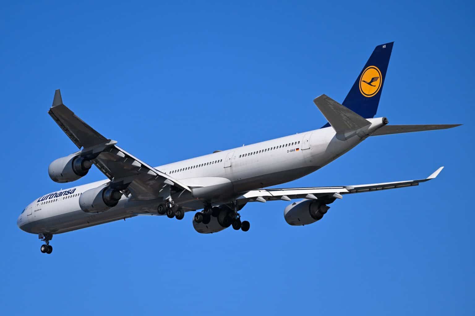 Lufthansa Airbus A340-600 D-AIHX on final approach to Boston with landing gear down against a blue sky