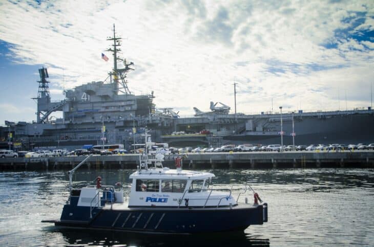 USS Midway moored at Navy Pier in San Diego as a museum ship, with a harbor police boat in the foreground