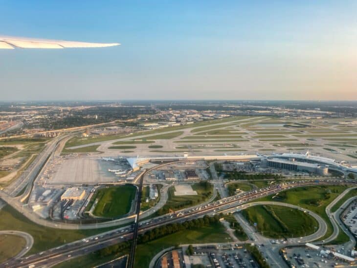 Aerial view of Chicago O'Hare airport at dusk, with terminals, aprons and runways spread across the airfield