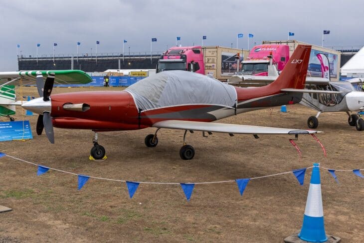 Red Lancair IV-P VH-XL7 with a protective cover over its canopy on display at an airshow in Australia
