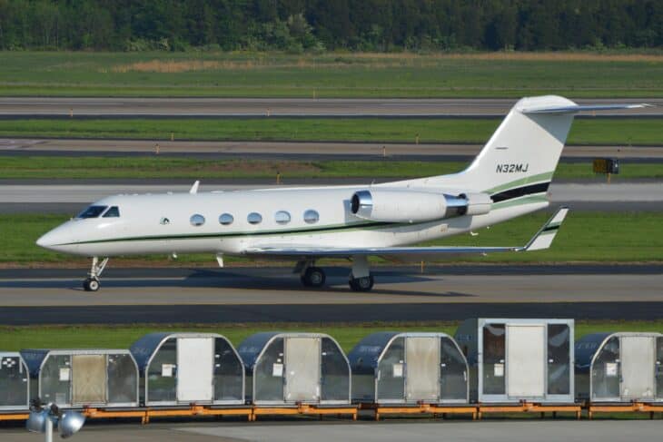 Gulfstream III N32MJ taxiing past cargo containers