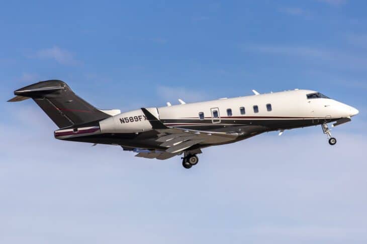 Flexjet Bombardier Challenger 350 N589FX in the dark Flexjet livery climbing out under a blue sky