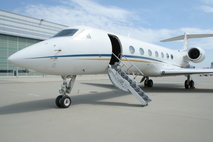 White Gulfstream G550 with its airstair door open on the ramp