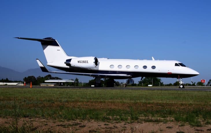 White Gulfstream G-IV business jet on the runway with its gear down