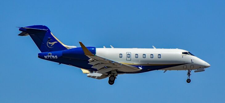 Blue and white Bombardier Challenger 350 in flight with its gear down