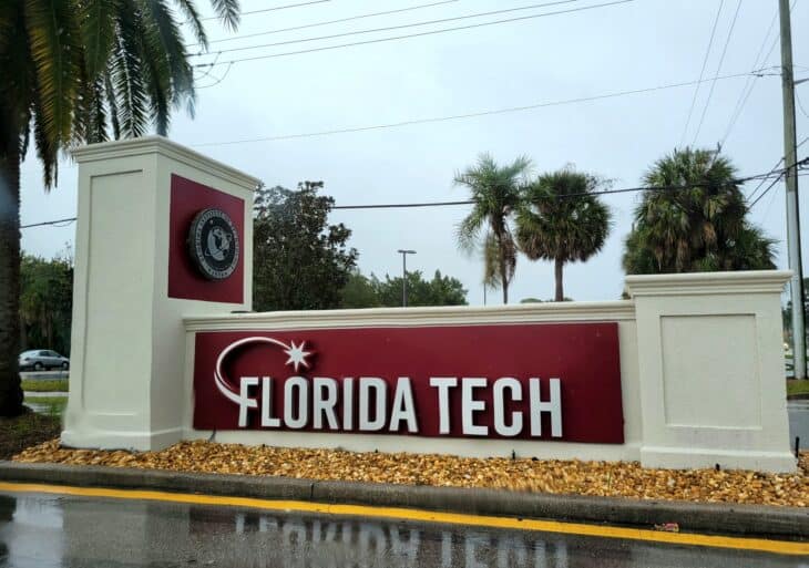 Florida Tech entrance sign with the school name in white on a red panel