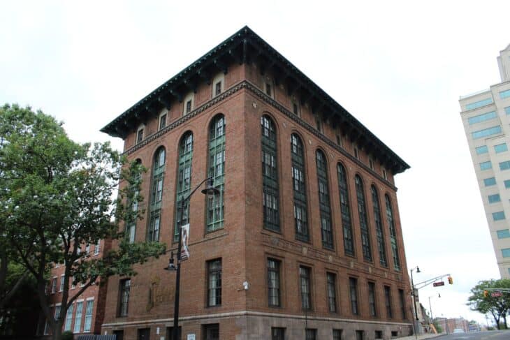 Brick Thomas Edison State University building with arched windows on a city street in Trenton