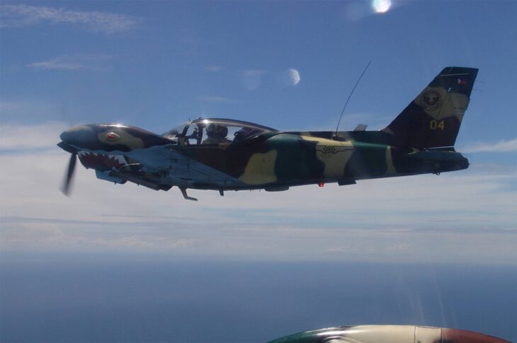 Philippine Air Force SF-260 in camouflage flying over the sea