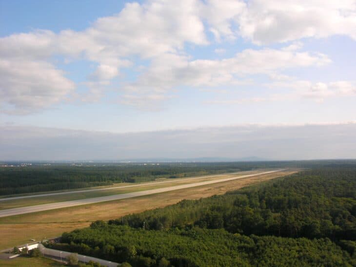 Aerial view of Frankfurt Airport's Runway 18 West stretching through forest