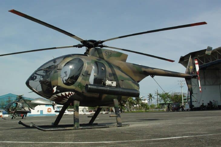 Philippine Air Force MD 520MG light attack helicopter with camouflage and shark-mouth nose parked on a helipad