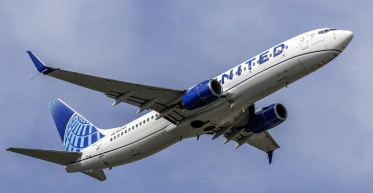 United Airlines Boeing 737-800 climbing out against a cloudy sky