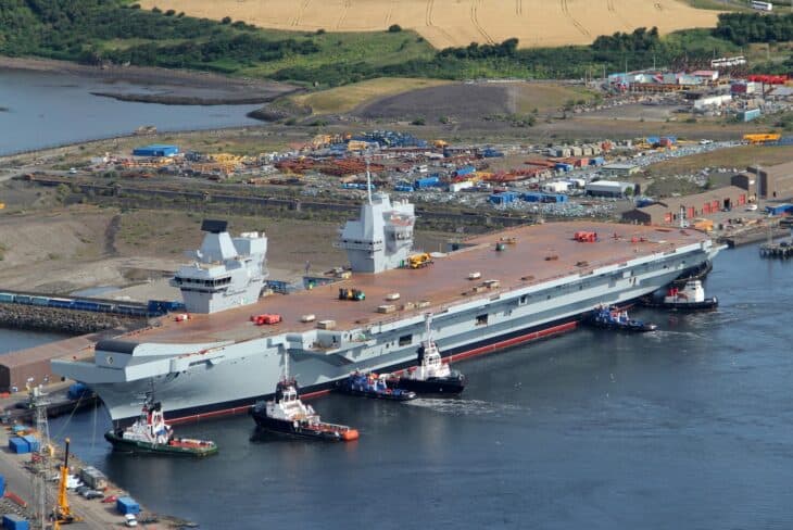 HMS Queen Elizabeth alongside at Rosyth Dockyard with tugs beside her
