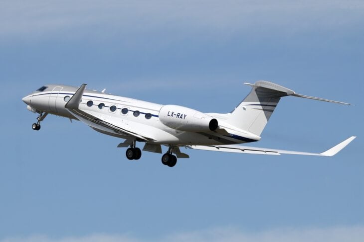 Gulfstream G650ER LX-RAY climbing out after takeoff against a blue sky, registration visible on the engine nacelle