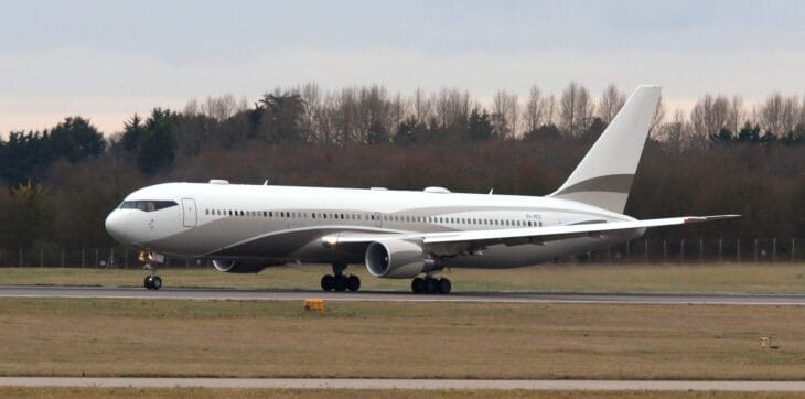 Boeing 767-300ER P4-MES in grey-and-white livery with a dark cockpit band, taxiing