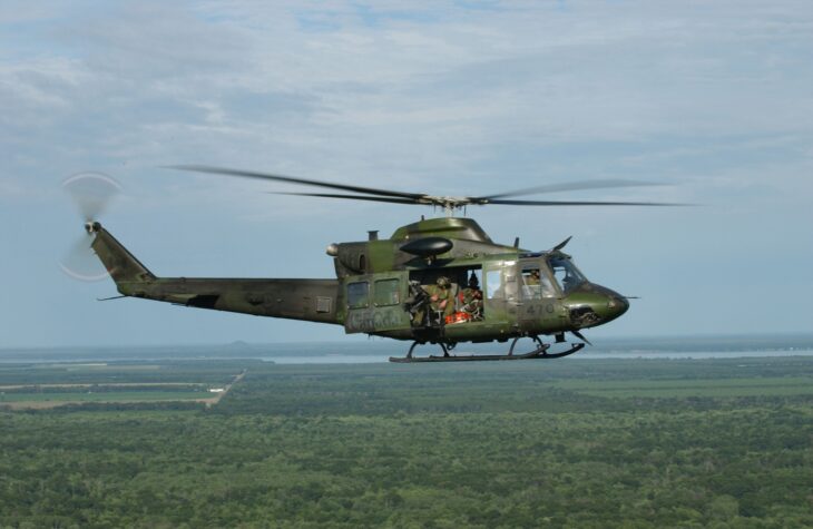 Canadian CH-146 Griffon helicopter in flight over forest