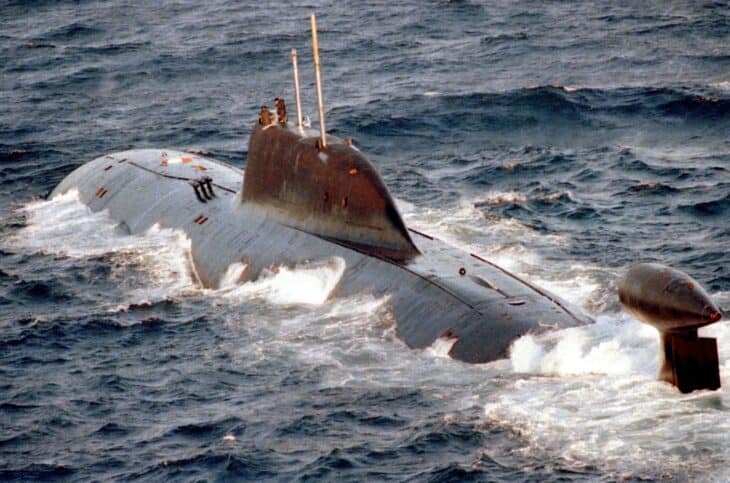 Akula-class submarine surfacing with water streaming off the hull