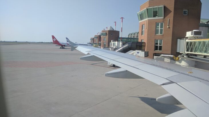Terminal and control tower at Venice Marco Polo Airport seen past an aircraft wing