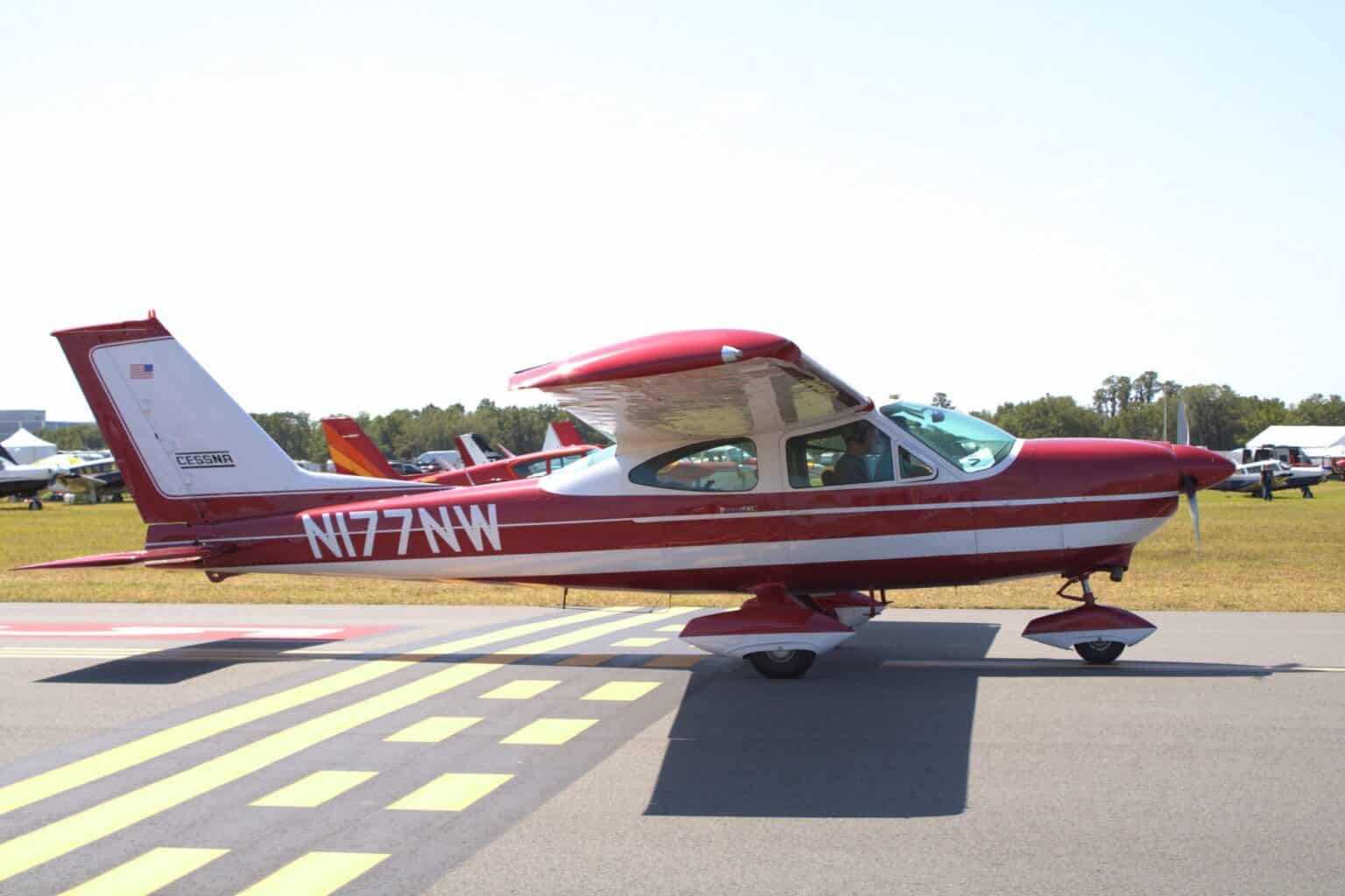 Red and white Cessna 177A Cardinal N177NW on a runway threshold