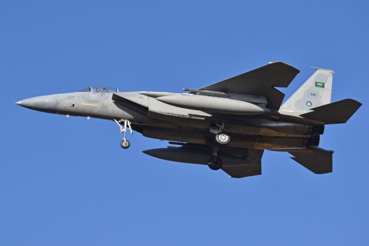 Royal Saudi Air Force F-15C Eagle 515 in flight against a blue sky with its landing gear down