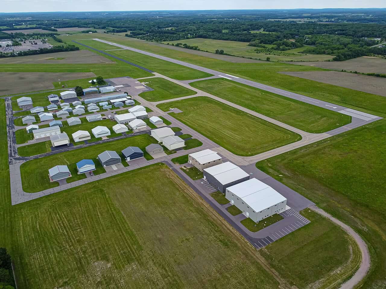 Aerial view of Baraboo-Wisconsin Dells Regional Airport, its hangar rows and paved runway surrounded by farmland in Sauk County, Wisconsin