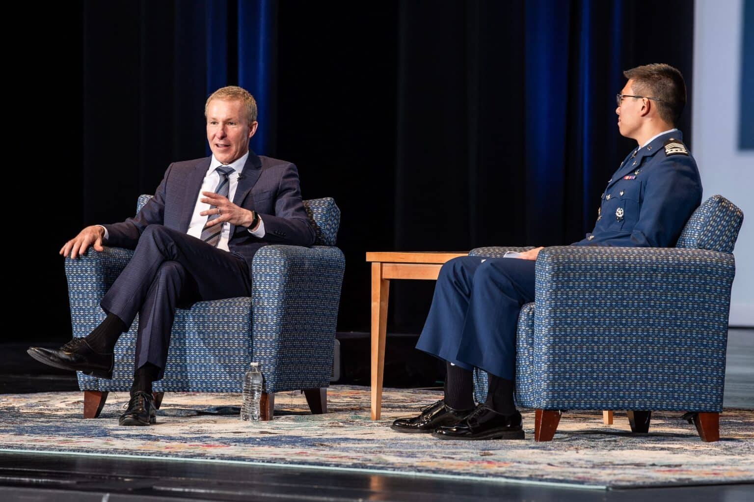 United Airlines CEO Scott Kirby seated on stage in conversation at the Air Force Academy leadership symposium in 2024