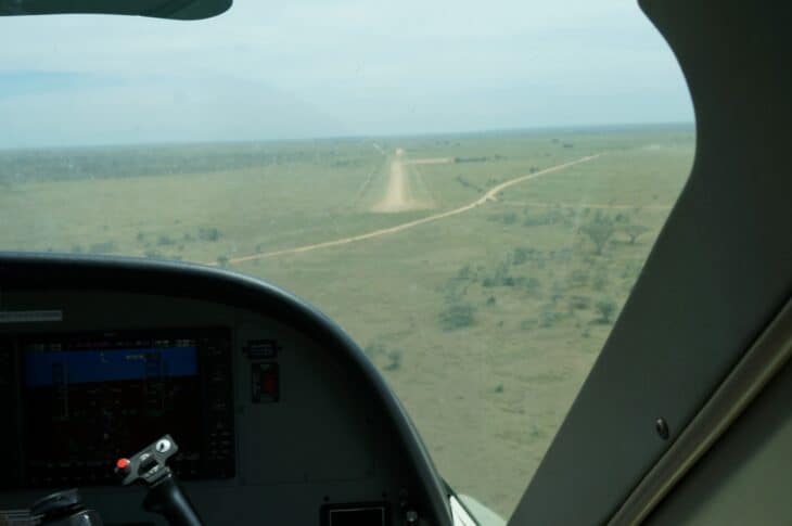 Seronera Airstrip's gravel runway seen through the windshield of an aircraft approaching across the Serengeti plains