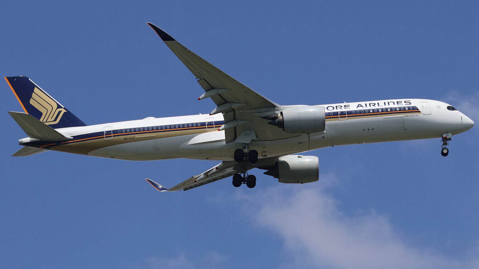 Singapore Airlines Airbus A350-900 9V-SJC in flight with its landing gear down against a blue sky