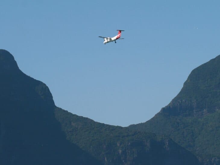 Qantas Link Dash 8 flying between the mountains on approach to Lord Howe Island