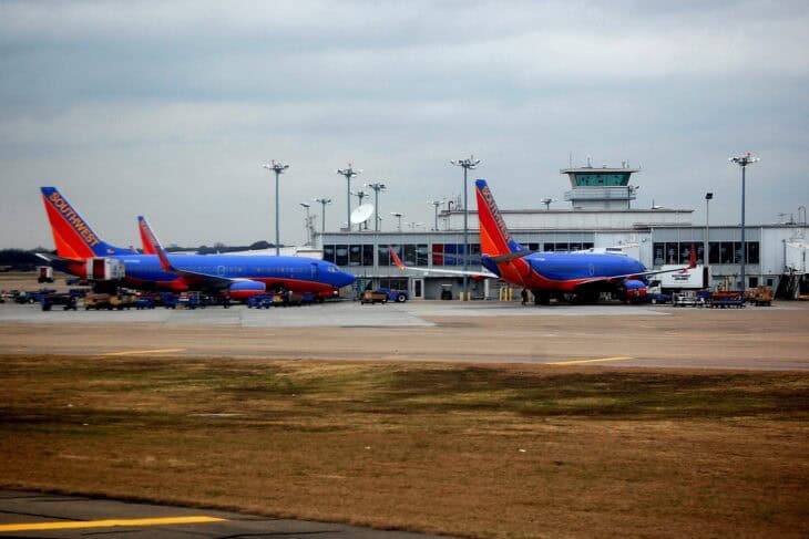 Southwest Airlines Boeing 737s parked at the West Concourse of Dallas Love Field under an overcast sky