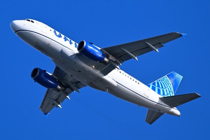 United Airlines Airbus A319 N841UA climbing away against a blue sky, with strips of speed tape on the wing